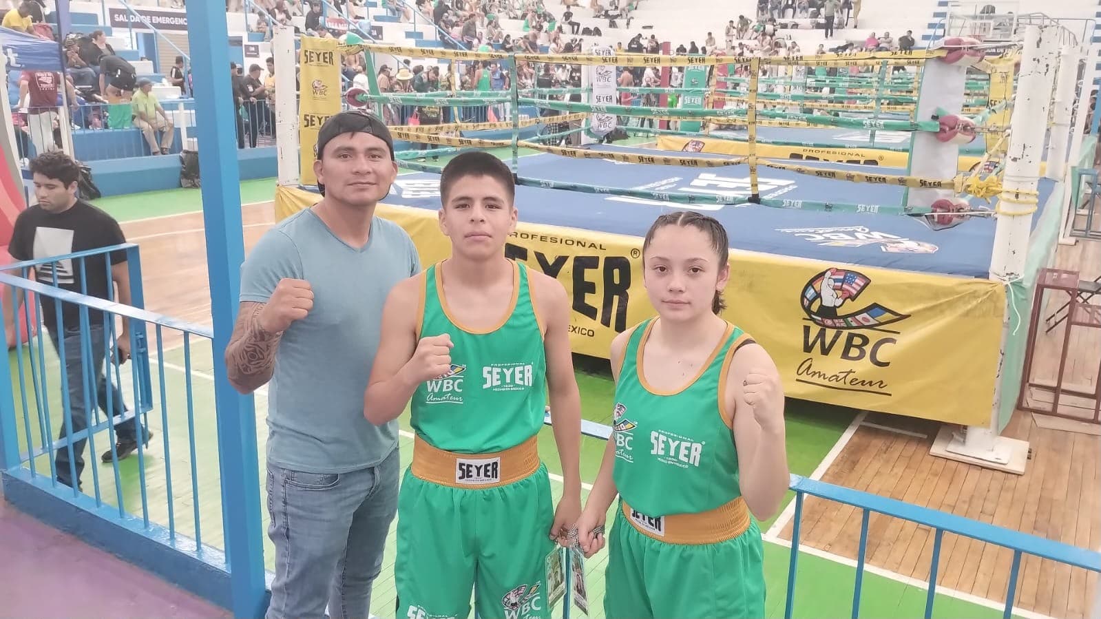 Coach y alumnos junto al ring de un torneo