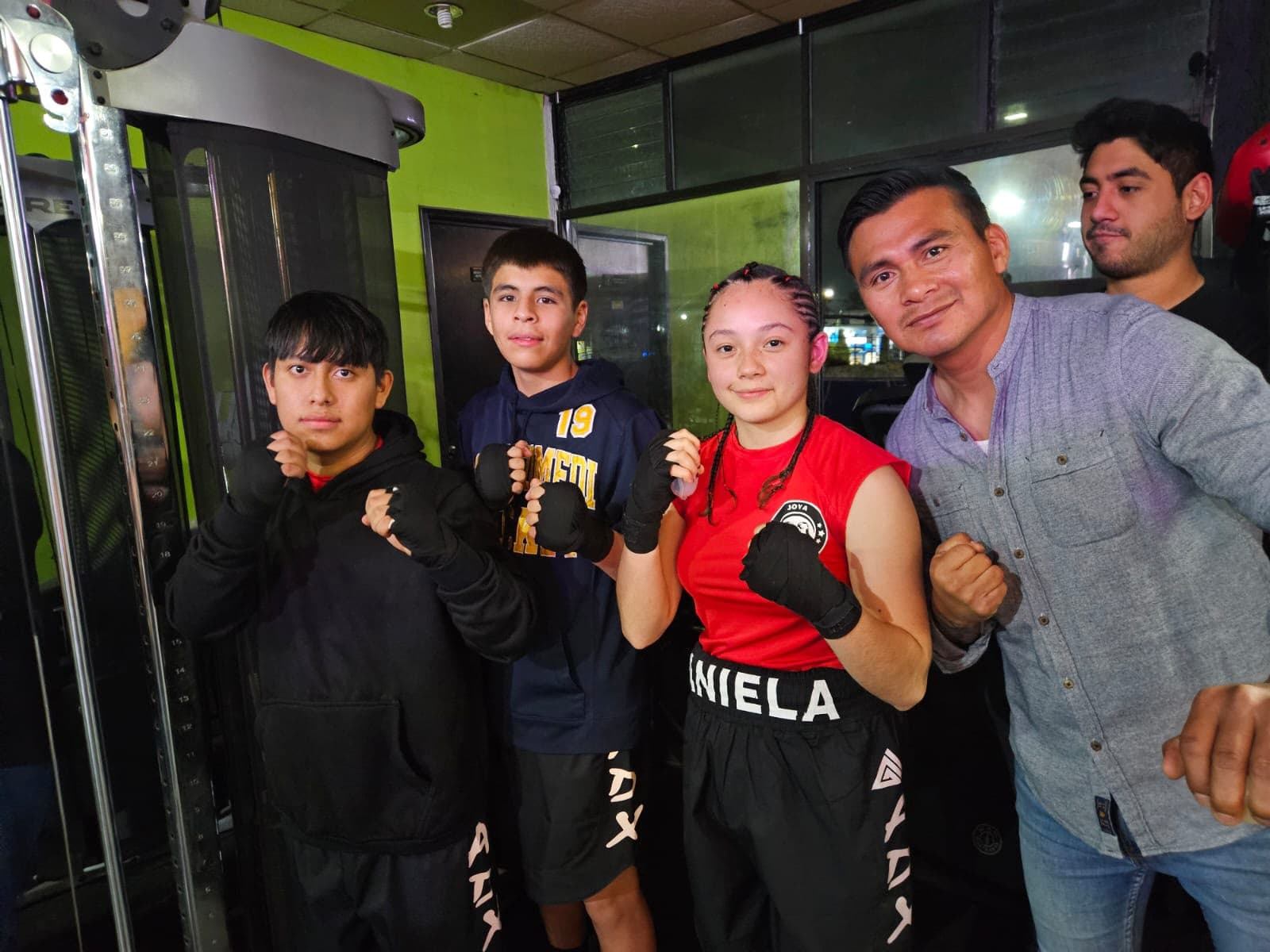 Alumnos con guantes de boxeo junto al coach